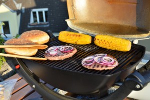 Burger und Mais gegrillt auf einem Elektro-Kugelgrill