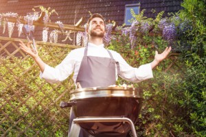 Glücklicher Grillmeister bei der Arbeit vor seinem Gas Kugelgrill