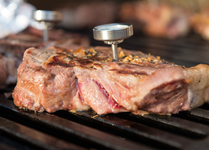 Thermometer steckt in Grillfleisch